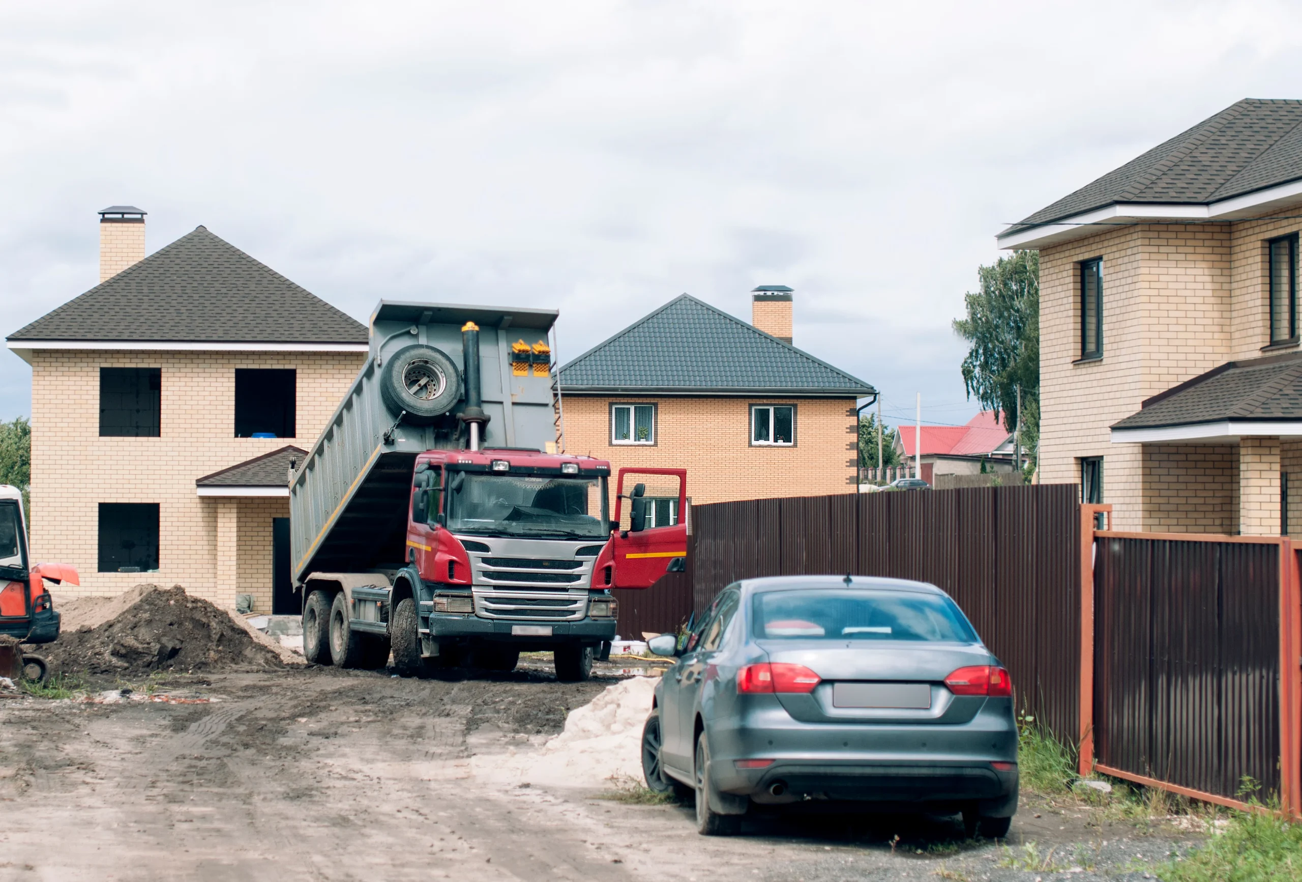 Construction of houses Construction of houses in the private sector. A truck unloads construction materials